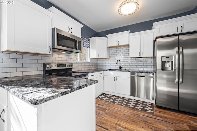 kitchen featuring white cabinets, backsplash, appliances with stainless steel finishes, dark hardwood / wood-style floors, and sink