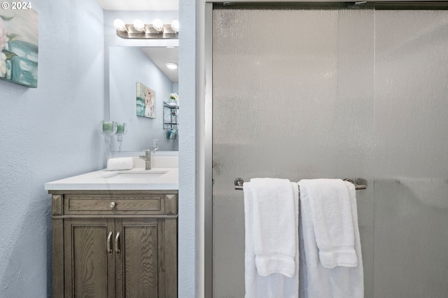 bathroom with vanity and a shower with shower door