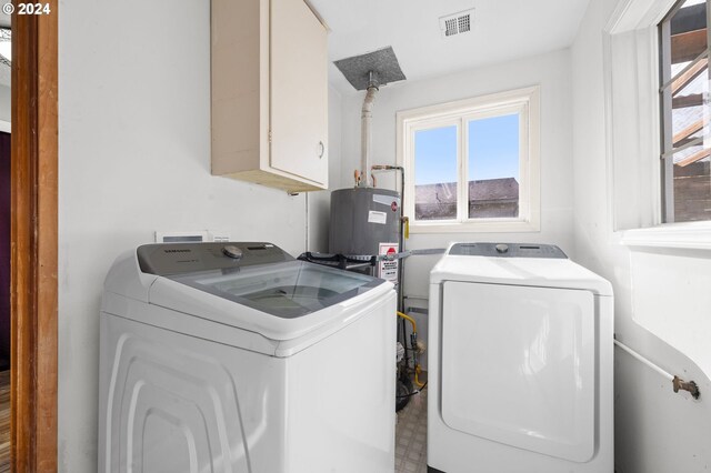 clothes washing area featuring cabinets and independent washer and dryer