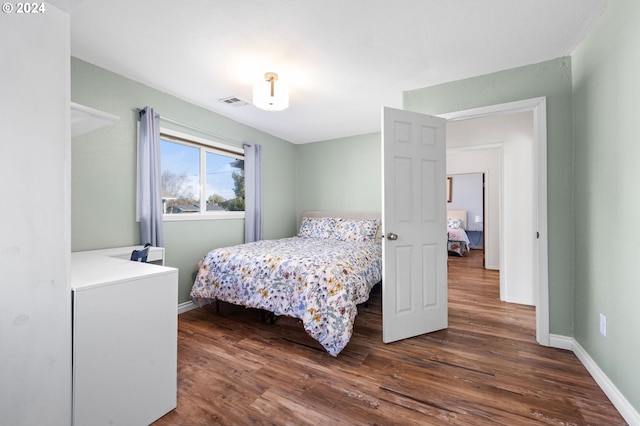 bedroom with dark hardwood / wood-style floors