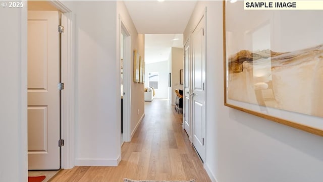 hall featuring light wood-style floors and baseboards