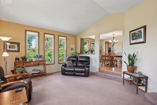 living area with lofted ceiling, carpet floors, a chandelier, a textured ceiling, and baseboards