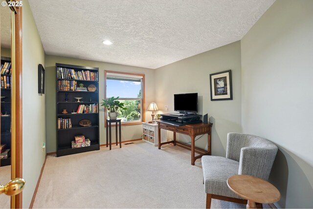 carpeted office space featuring a textured ceiling and baseboards