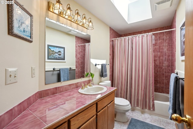 bathroom with toilet, shower / bath combo with shower curtain, vanity, tile patterned floors, and a skylight