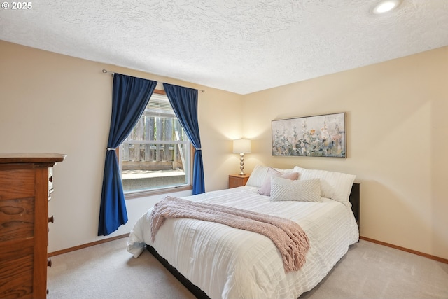 bedroom featuring carpet flooring, baseboards, and a textured ceiling
