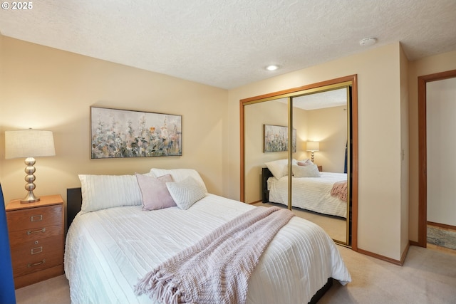 bedroom with light carpet, a closet, a textured ceiling, baseboards, and recessed lighting