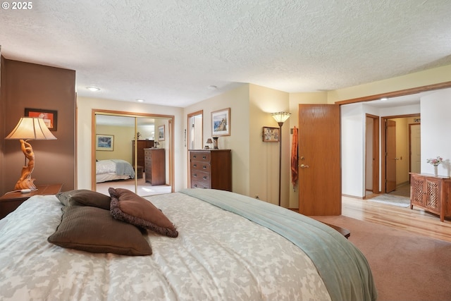 carpeted bedroom with a closet, a textured ceiling, and recessed lighting
