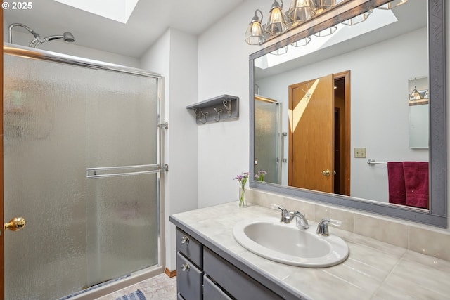 bathroom featuring a shower stall, a skylight, and vanity