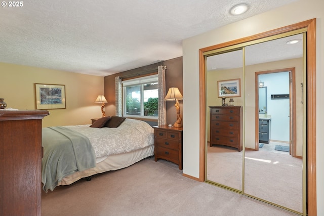 carpeted bedroom featuring a textured ceiling and a closet