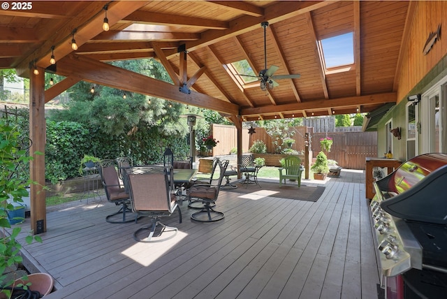 deck featuring outdoor dining area, ceiling fan, a fenced backyard, grilling area, and a gazebo