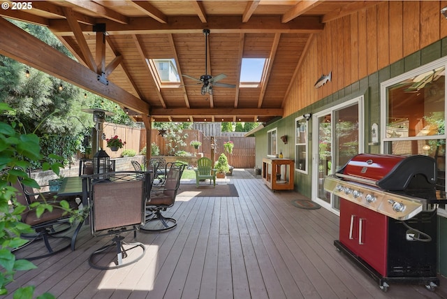 deck with outdoor dining space, a fenced backyard, and grilling area