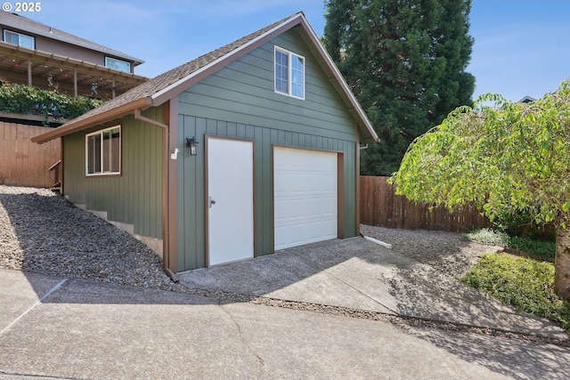 garage with fence and driveway
