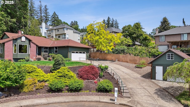 view of yard featuring a garage, a residential view, and fence