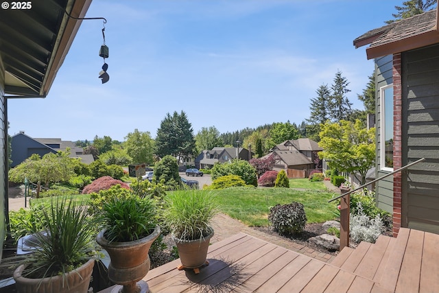 wooden terrace featuring a yard and a residential view