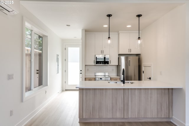 3727 N Michigan Ave, Portland, OR 97227 - kitchen with appliances with stainless steel finishes, a wall unit AC, light countertops, backsplash, and light wood-style floors