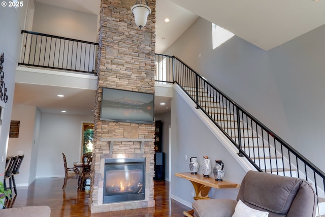 living room with a towering ceiling, dark hardwood / wood-style floors, and a fireplace