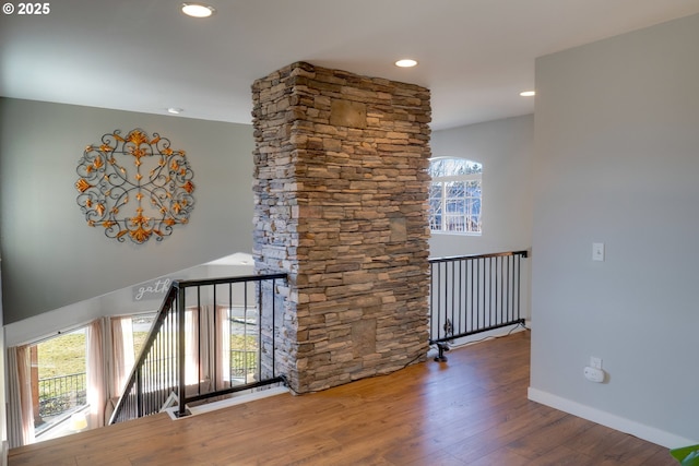 corridor featuring a healthy amount of sunlight and hardwood / wood-style floors