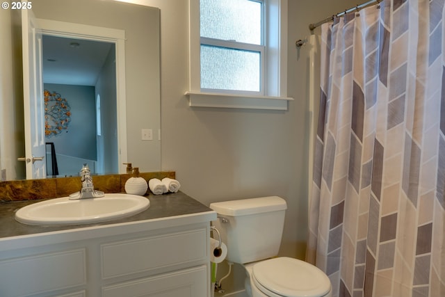 bathroom featuring vanity, toilet, and walk in shower