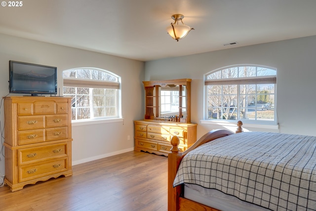 bedroom featuring multiple windows and light wood-type flooring