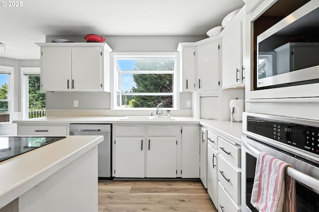 18135 SW Hart Dr, Beaverton, OR 97007 - kitchen featuring stainless steel appliances, light countertops, white cabinetry, and light wood-style flooring