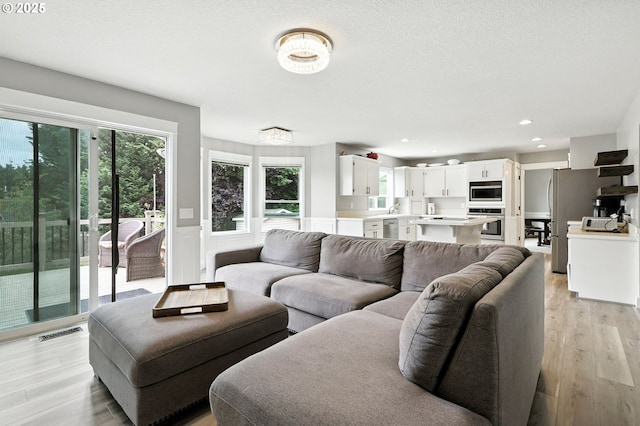 18135 SW Hart Dr, Beaverton, OR 97007 - living area featuring healthy amount of natural light, light wood-style flooring, recessed lighting, and a wainscoted wall
