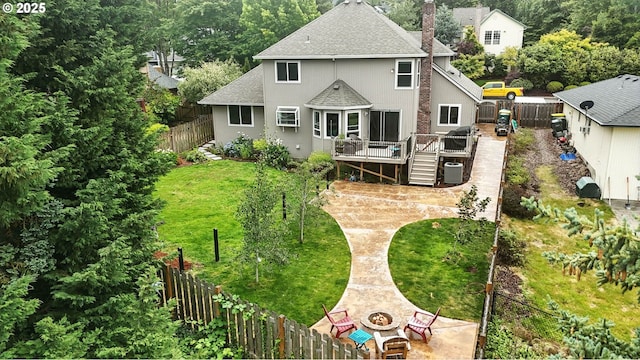 18135 SW Hart Dr, Beaverton, OR 97007 - back of house with roof with shingles, a fire pit, a wooden deck, a chimney, and a fenced backyard