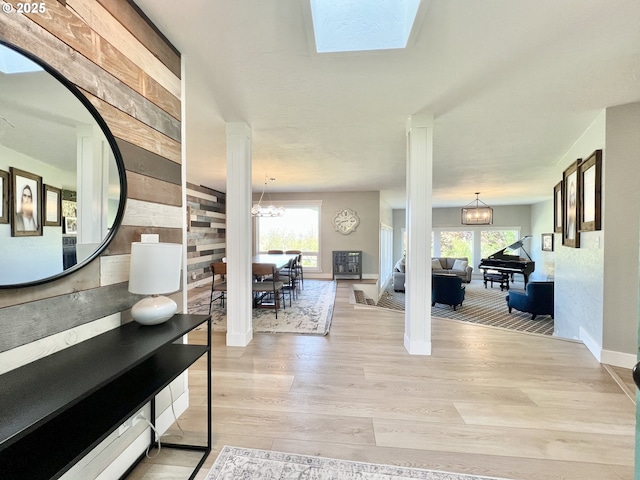 1082 E Highland Ave, Hermiston, OR 97838 - foyer with a chandelier, light wood finished floors, ornate columns, baseboards, and wooden walls