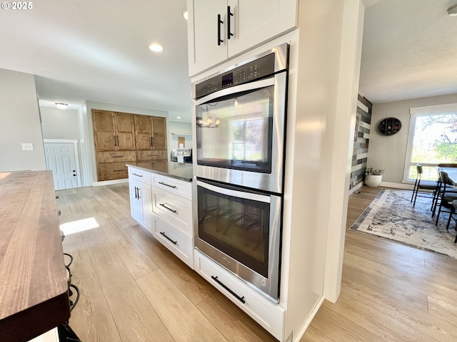 1082 E Highland Ave, Hermiston, OR 97838 - kitchen featuring double oven, light wood-style flooring, white cabinets, recessed lighting, and baseboards