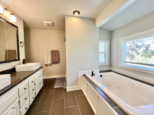 1082 E Highland Ave, Hermiston, OR 97838 - bathroom with double vanity, a tub with jets, and baseboards