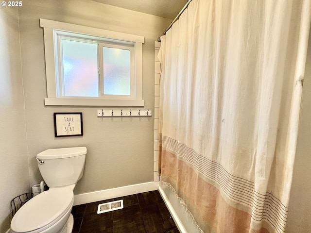 1082 E Highland Ave, Hermiston, OR 97838 - bathroom with baseboards, toilet, a shower with curtain, and wood finished floors