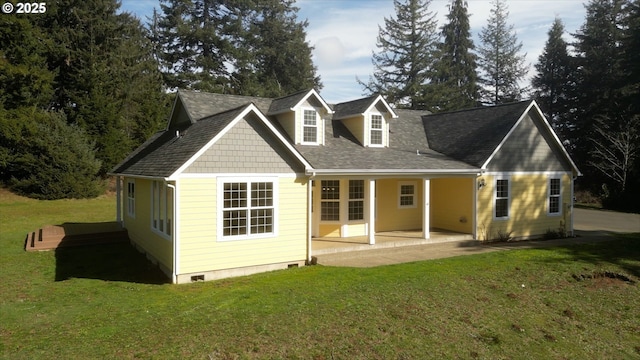 back of property with a shingled roof, crawl space, a lawn, and a patio