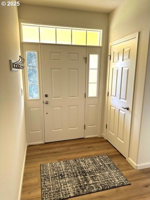 entrance foyer featuring baseboards and wood finished floors