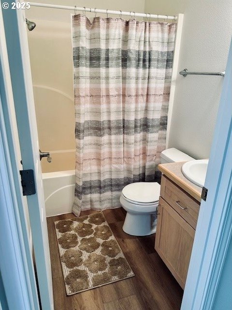 full bathroom with toilet, shower / bath combination with curtain, wood finished floors, and vanity