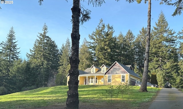 new england style home with an attached garage and a front yard