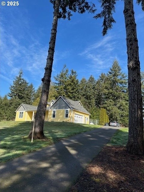 view of front facade featuring driveway, a front lawn, and an attached garage