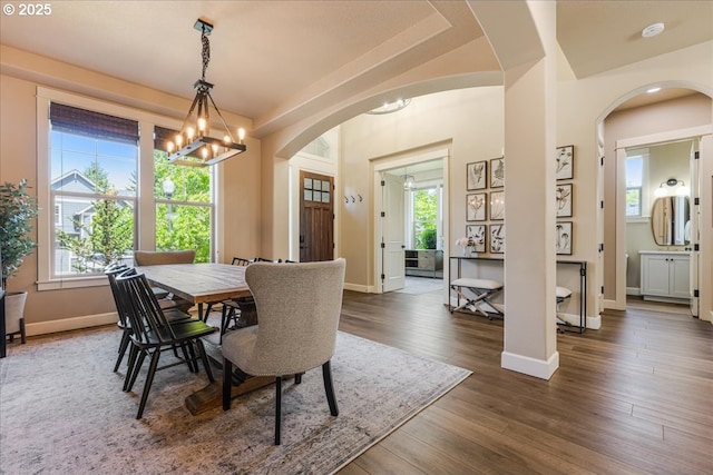 8614 SW Logan Ln, Tualatin, OR 97062 - dining area featuring a chandelier, arched walkways, healthy amount of natural light, and baseboards
