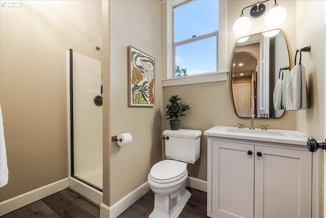 8614 SW Logan Ln, Tualatin, OR 97062 - full bathroom with a shower stall, wood finished floors, toilet, vanity, and baseboards