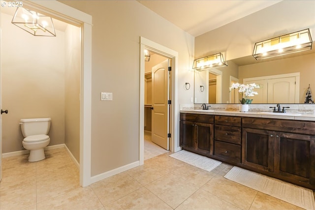 8614 SW Logan Ln, Tualatin, OR 97062 - bathroom with tile patterned floors, toilet, double vanity, baseboards, and a walk in closet
