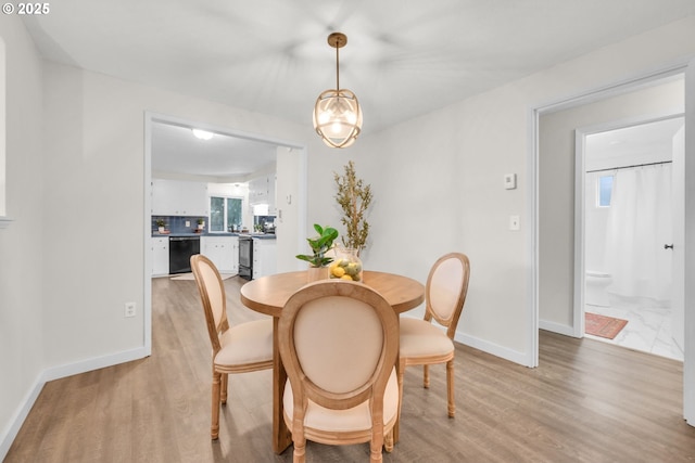 dining area with light wood-style floors and baseboards