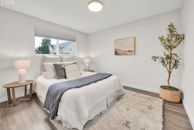 bedroom featuring baseboards and wood finished floors