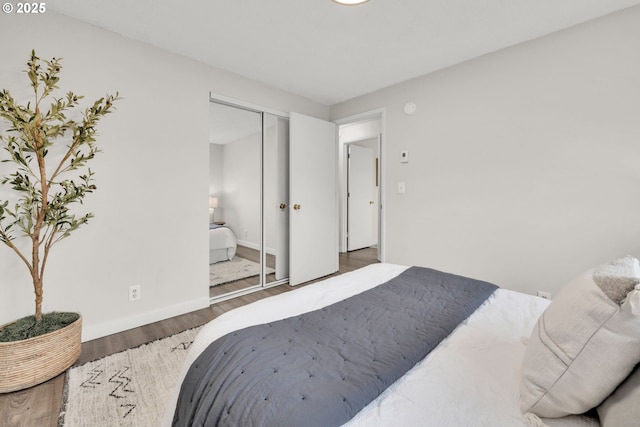 bedroom featuring a closet, baseboards, and wood finished floors