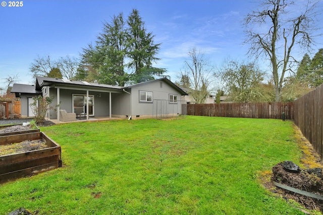 view of yard with a patio area, a vegetable garden, and a fenced backyard