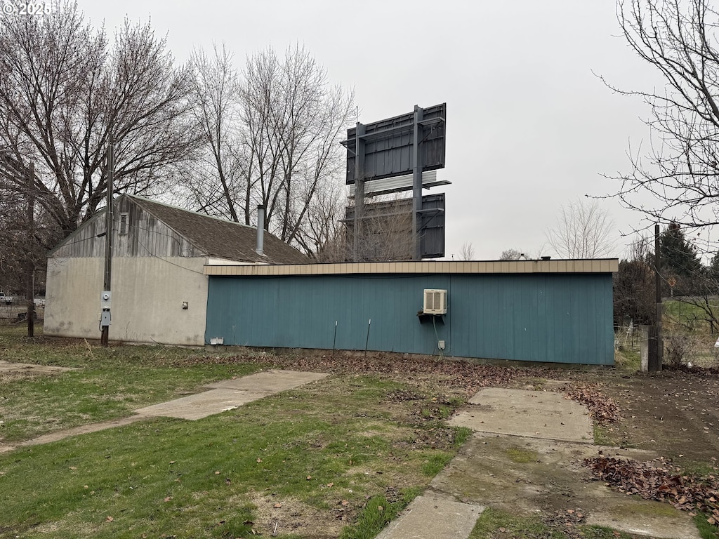 view of home's exterior featuring a wall unit AC and a lawn