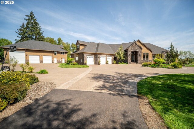 french country style house featuring driveway and stone siding