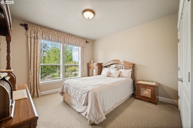 bedroom with baseboards and light colored carpet