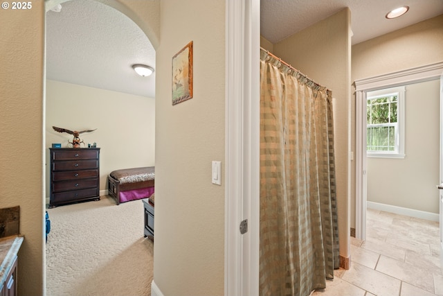 bathroom featuring a textured ceiling, a shower with shower curtain, and tile patterned floors