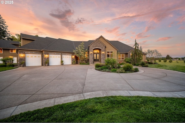 view of front facade with a garage, a front yard, stone siding, and concrete driveway