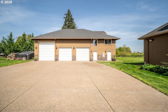 exterior space featuring a garage, concrete driveway, a yard, and stone siding