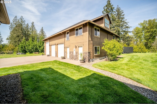 view of side of home with a lawn, a garage, and driveway