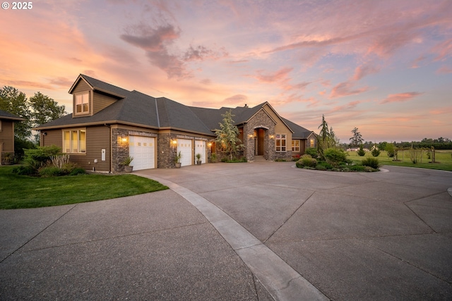view of front of house featuring a garage, concrete driveway, a front yard, and stone siding